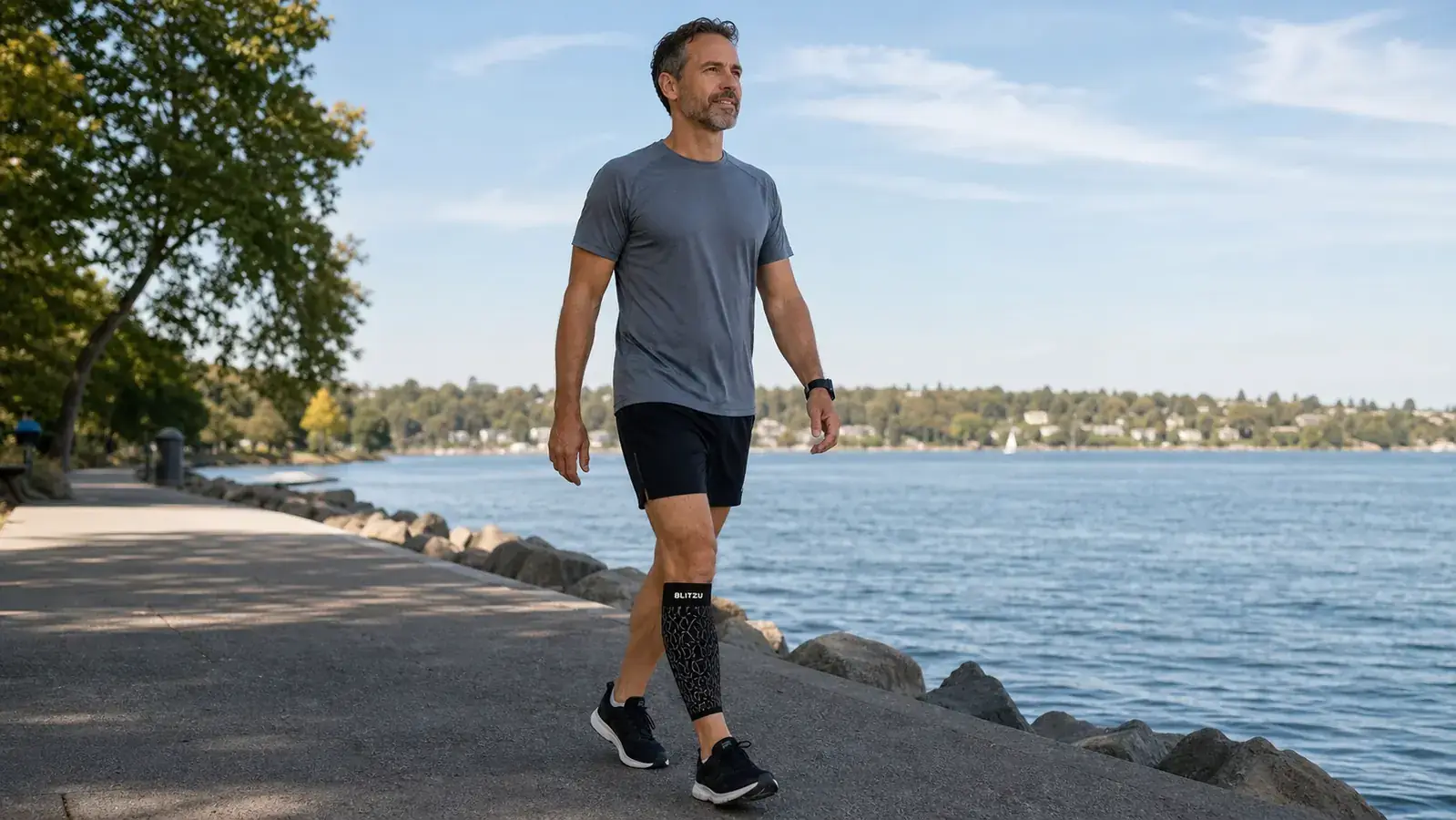 Close-up of a runner pulling on a black BLITZU calf compression sleeve before a run