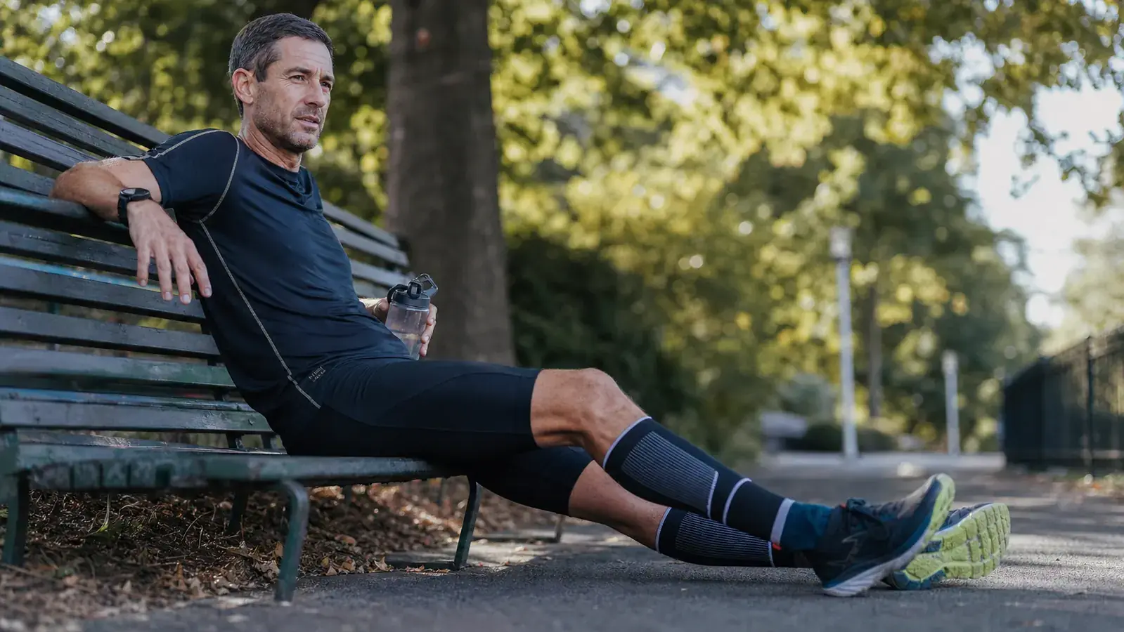 Runner's calves mid-stride on a trail, compression sleeves visible in motion