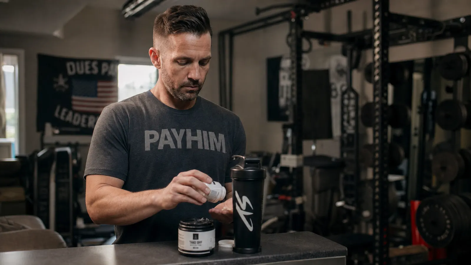 Athlete sitting on a gym bench after a workout, taking a supplement with a glass of water